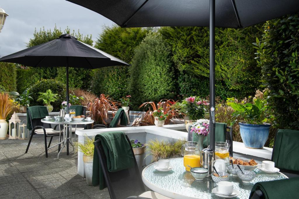 un patio esterno con tavoli e ombrellone di Killarney Lodge a Killarney