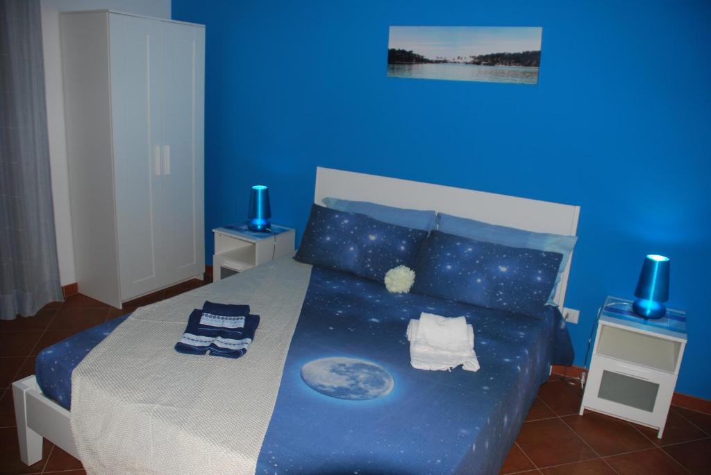 a blue bedroom with a bed with a blue wall at Eolo in Marsala