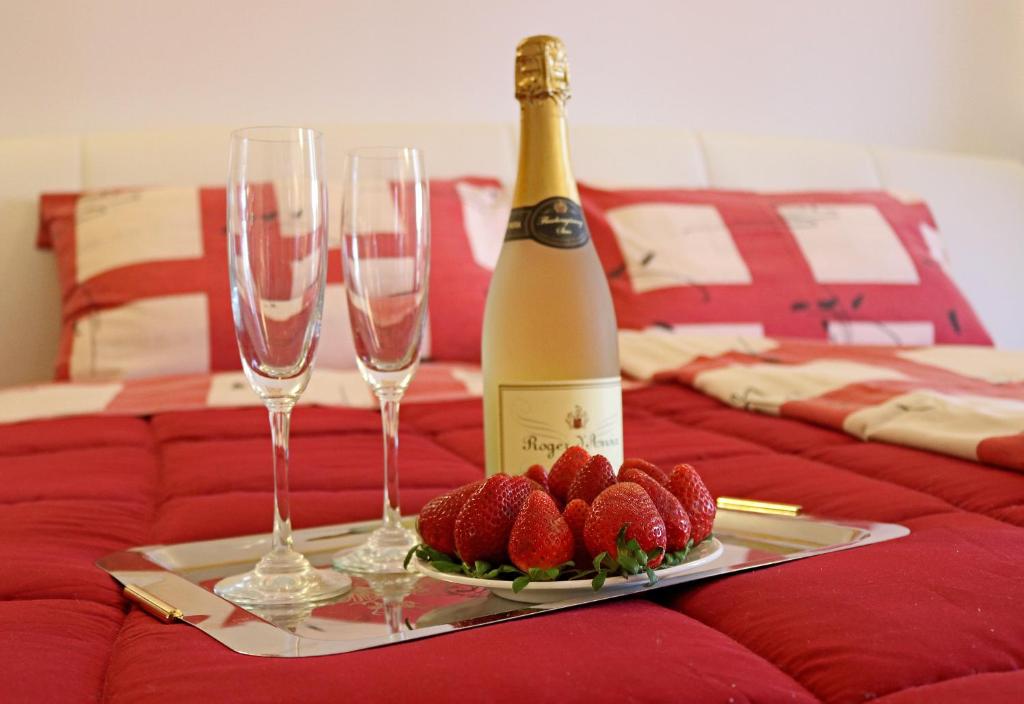 a bottle of wine and two wine glasses and strawberries at Apartments Medulin - Orijeta in Medulin