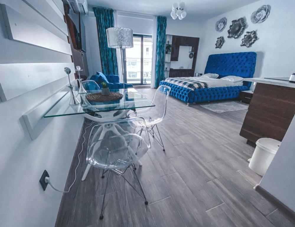 a living room with a glass table and a bed at Mamaia Luxury Studio Apartment V in Mamaia