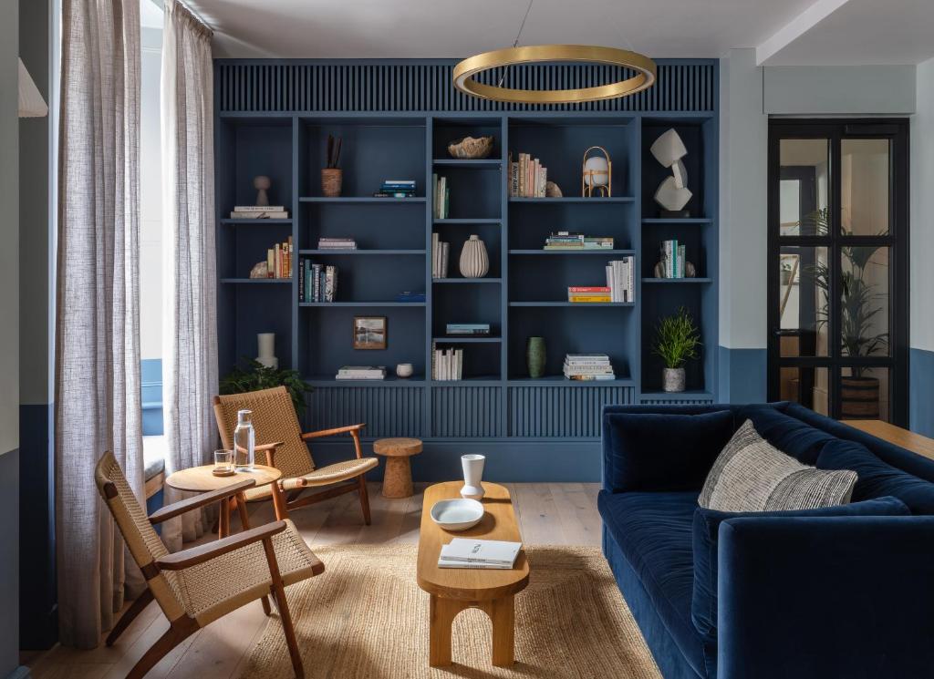 a living room with blue walls and a blue couch at Inhabit Southwick Street, a Member of Design Hotels in London