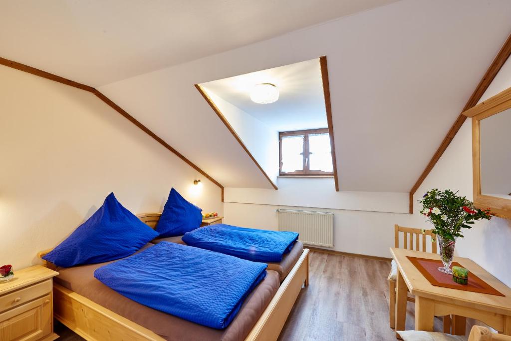 two beds in a room with blue pillows at Landgasthof Penn in Windorf