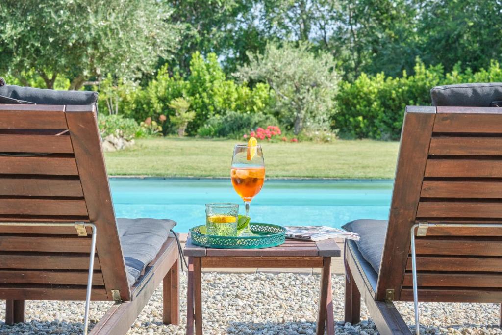 un vaso de zumo sentado en una mesa junto a dos sillas en Tenuta EDONE' Country House en Graniti