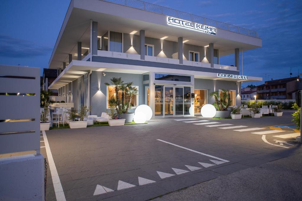 un bâtiment avec un parking en face de celui-ci dans l'établissement Hotel Kuma, à San Giuseppe