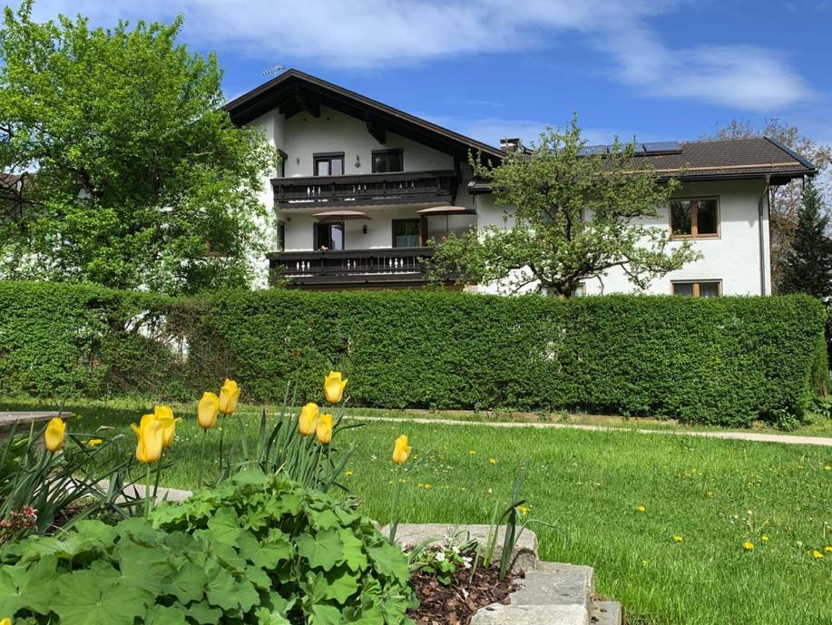 a house with yellow flowers in front of a yard at Ferienwohnungen Irmengard in Bernau am Chiemsee