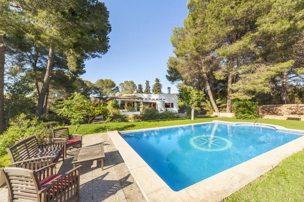 a swimming pool with chairs and a house at Sa Rota de l'Avi - Can Colombas in La Aranjasa