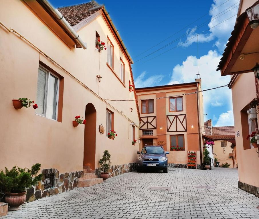 a car parked in a street between two buildings at Pensiunea Casa Sighisoreana in Sighişoara