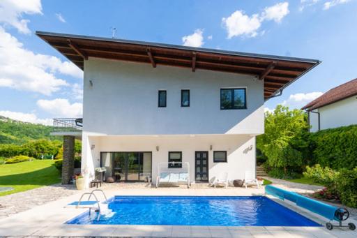 une maison avec une piscine en face de celle-ci dans l'établissement Villa Sendy Sarajevo, à Sarajevo