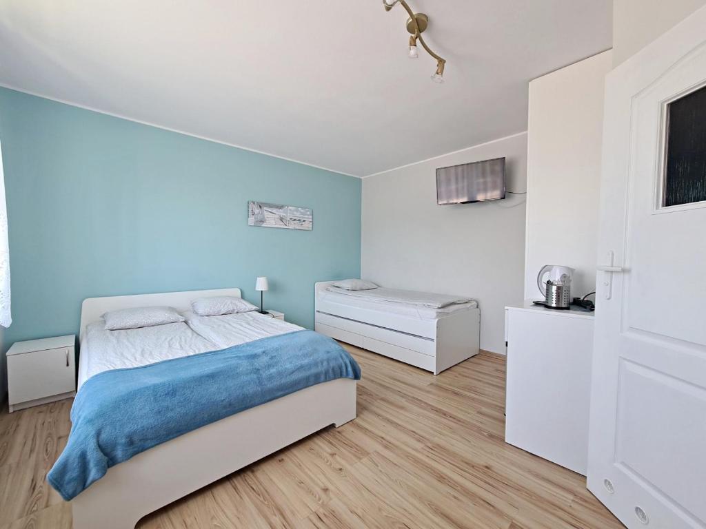 a white bedroom with a bed and a desk at Chatka Morska 3 in Karwia