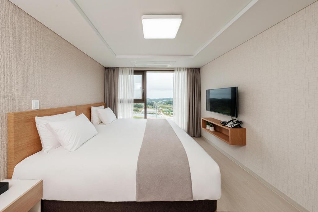 um quarto de hotel com uma cama e uma televisão em CENTUMMARK Hotel YangYang em Yangyang