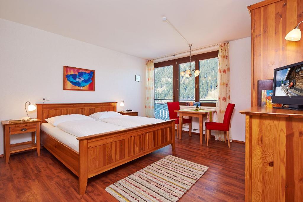 1 dormitorio con 1 cama, TV y mesa en SkyLounge Mayrhofen, en Mayrhofen