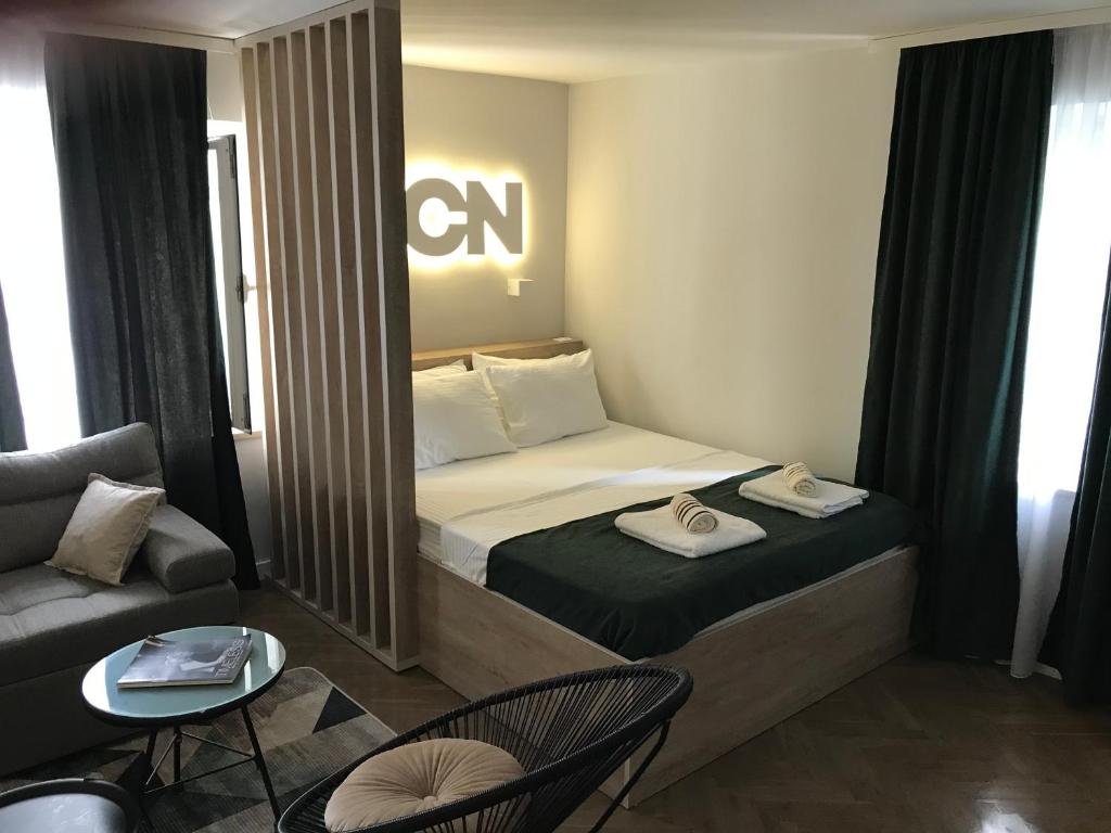 a small hotel room with a bed and a couch at Lux - Apartment BCN in Budva