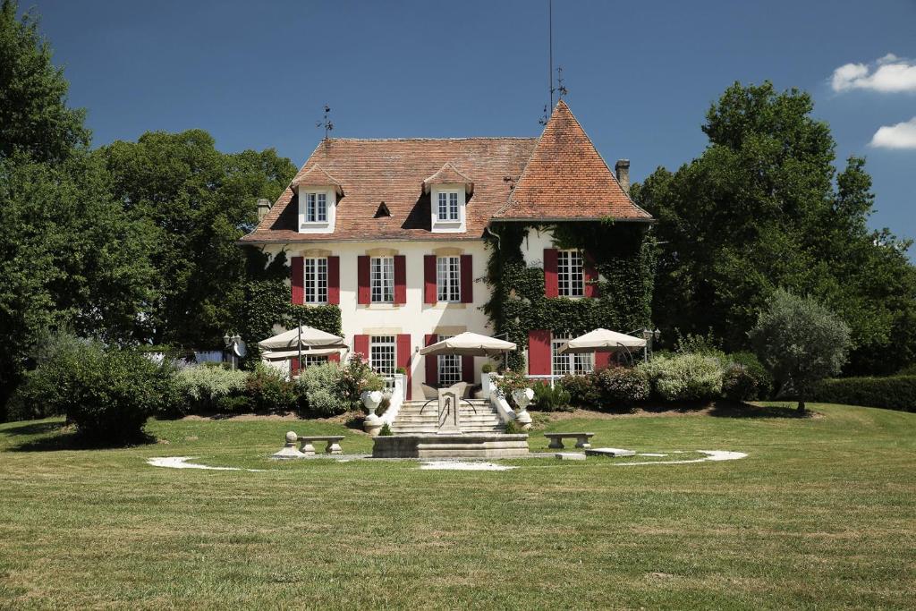 une grande maison avec une fontaine en face de celle-ci dans l'établissement Chateau la Tilleraie, à Bergerac