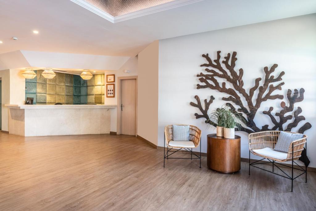 a lobby with two chairs and a painting of an aquarium at Hotel LIVVO Puerto de Mogán in Puerto de Mogán