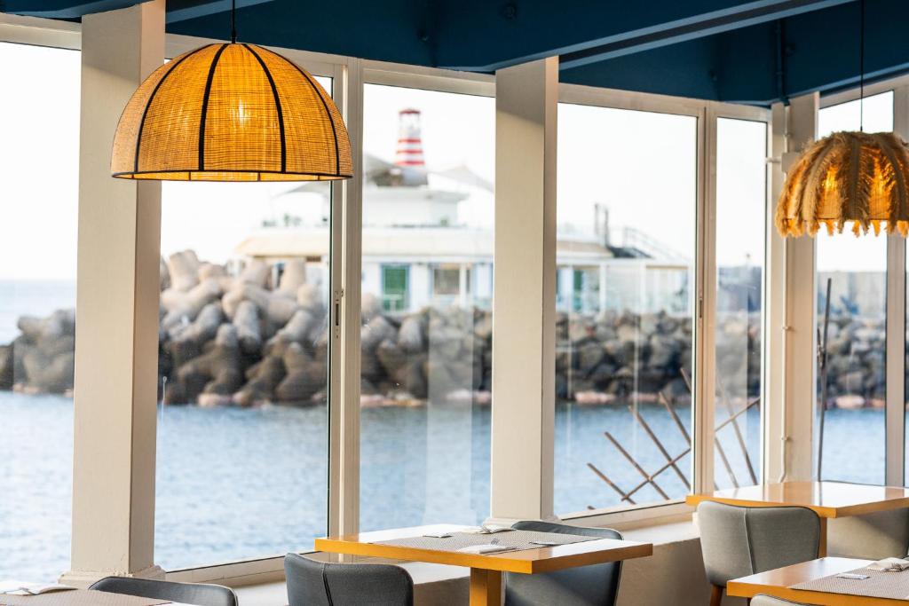 a restaurant with two tables and chairs and windows at Hotel LIVVO Puerto de Mogán in Puerto de Mogán