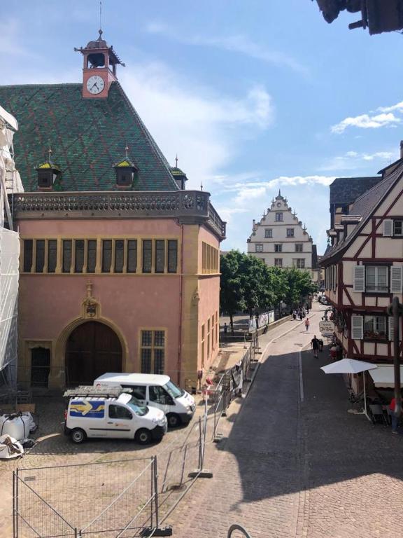 un bâtiment avec une voiture garée devant dans l'établissement Les appartements du Koifhus, à Colmar