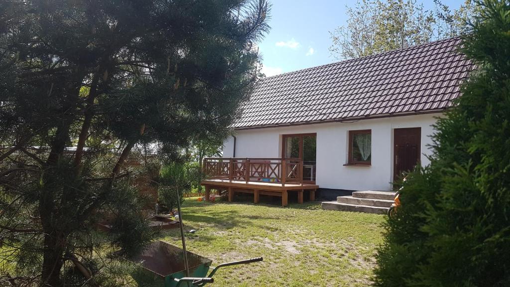 uma casa branca com um alpendre e um deque em Dom Na Skarpie - Ucieczka Na Wieś - Kominek em Drążek