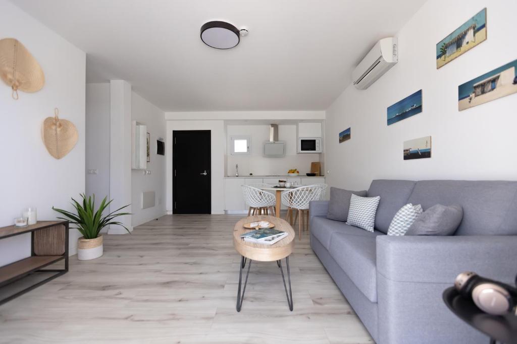 a living room with a blue couch and a table at Island Home Fuerteventura in Corralejo