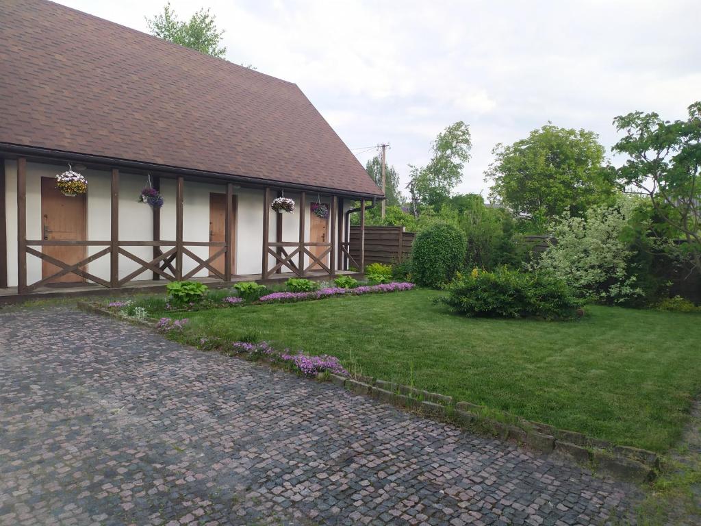 ein Haus mit einer steinernen Einfahrt vor einem Hof in der Unterkunft House of Vitaliy in Potschajiw