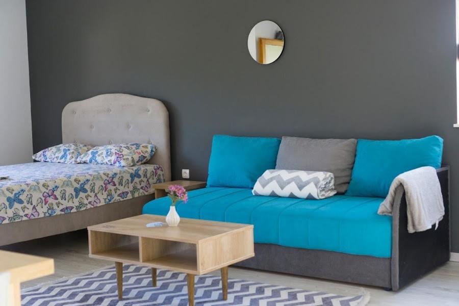 a living room with a blue couch and a table at Apartments Ena in Trebinje