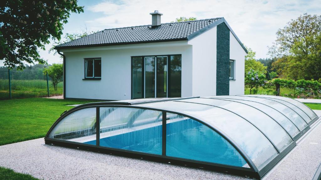 uma casa com piscina e telhado de vidro em Vilka Petra pod Bezdězem em Weisswasser in Böhmen