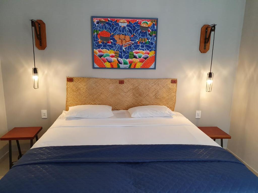 a bed in a bedroom with a painting on the wall at Antheia Ponta do Seixas in João Pessoa