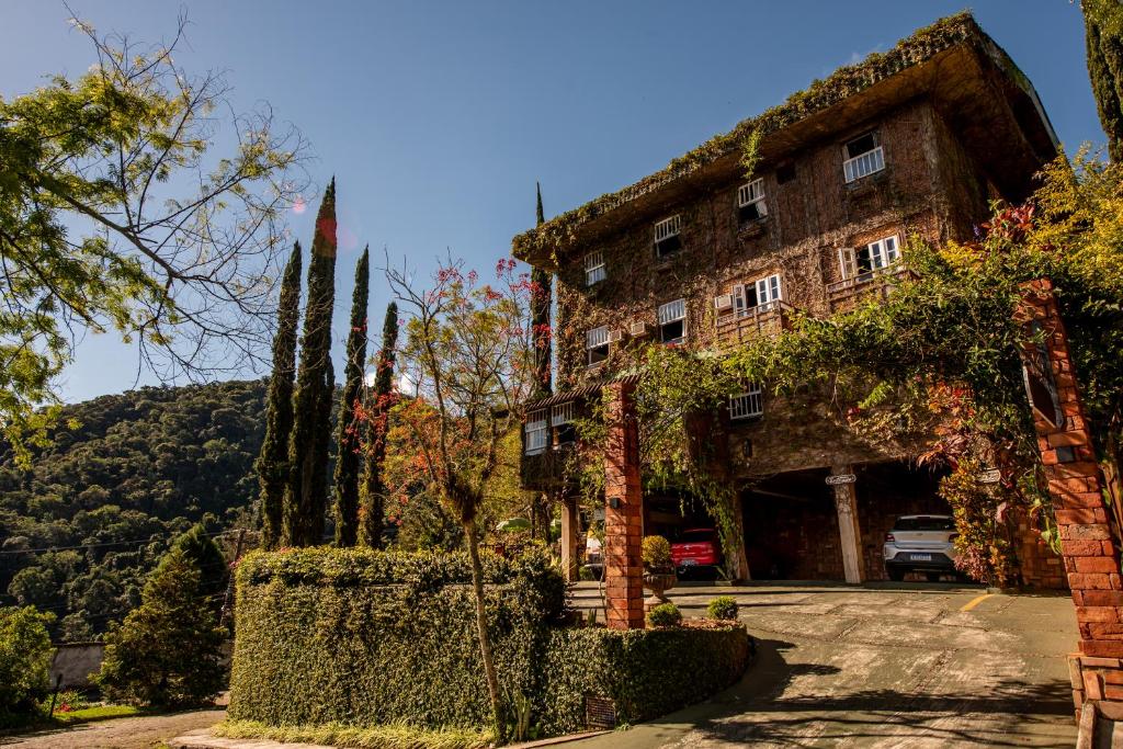 um grande edifício de pedra com árvores em frente em Pousada Monte Imperial em Petrópolis