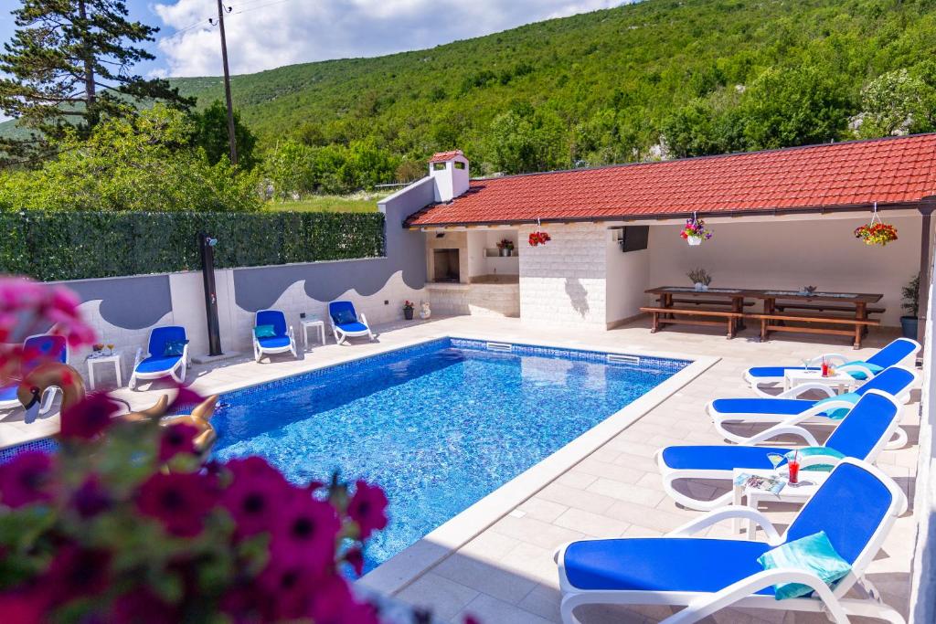 - une piscine avec des chaises longues et une table dans l'établissement VILLA HILL STARS, Makarska- Slivno, à Slivno