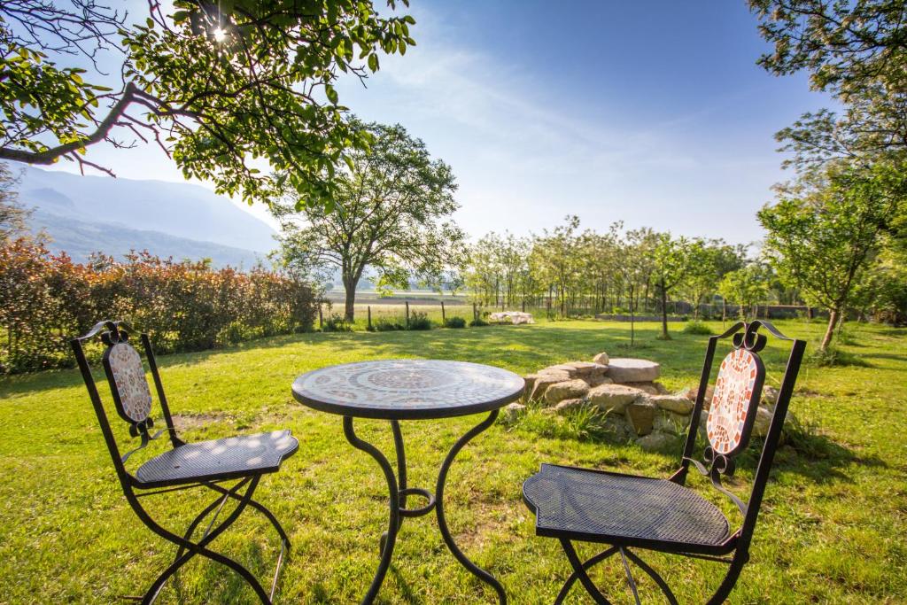 two chairs and a table in the grass with a table and chairs at Apartment Otava in Šempas