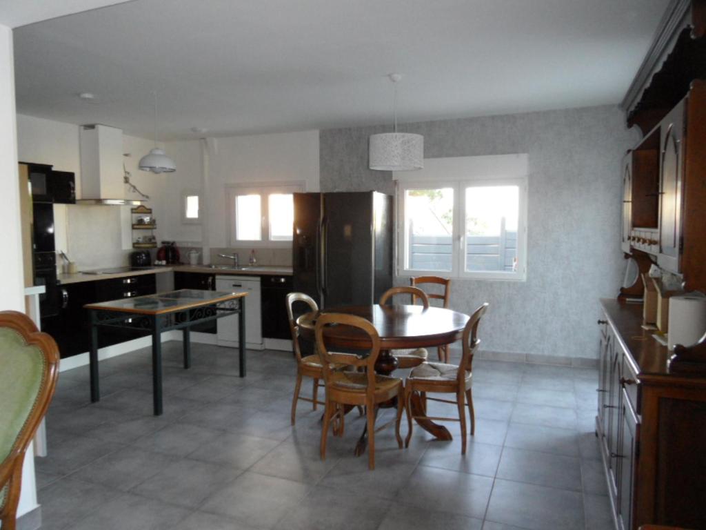 eine Küche mit einem Tisch und Stühlen sowie ein Esszimmer in der Unterkunft logement entre mer et montagne in Roujan