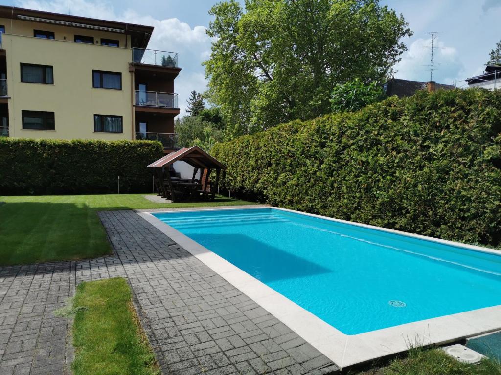 a swimming pool in front of a house at Noémi Wellness Apartman in Siófok