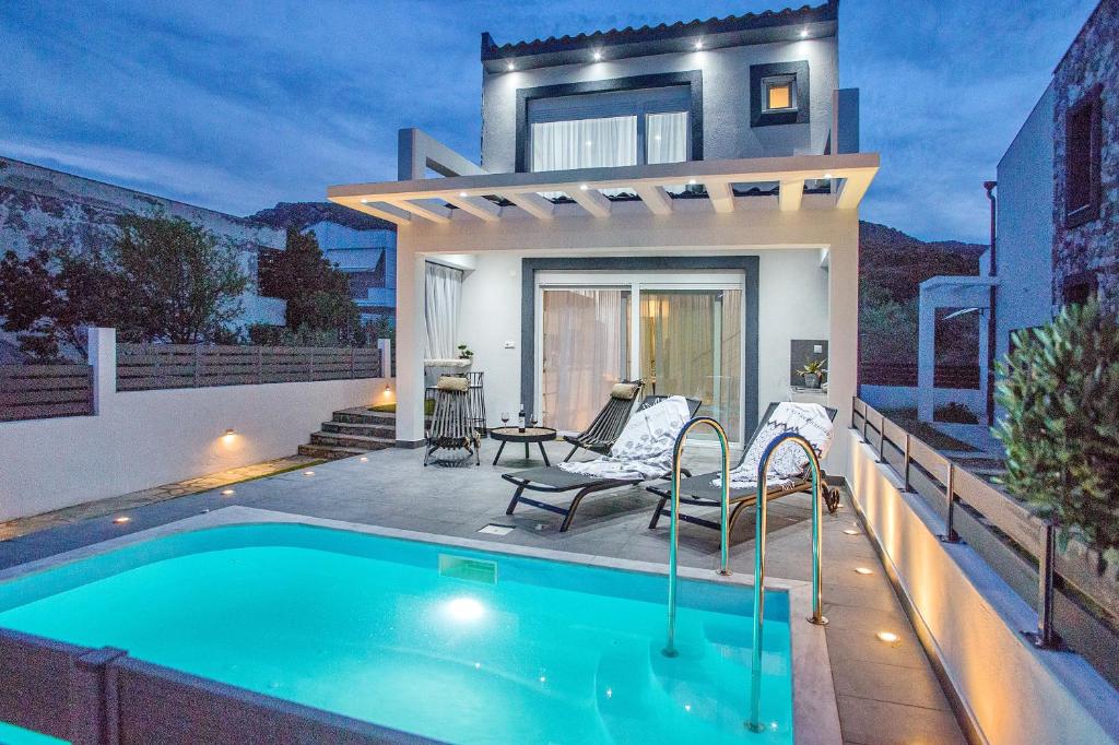 a house with a swimming pool in front of a house at JOY C Deluxe in Iraklitsa