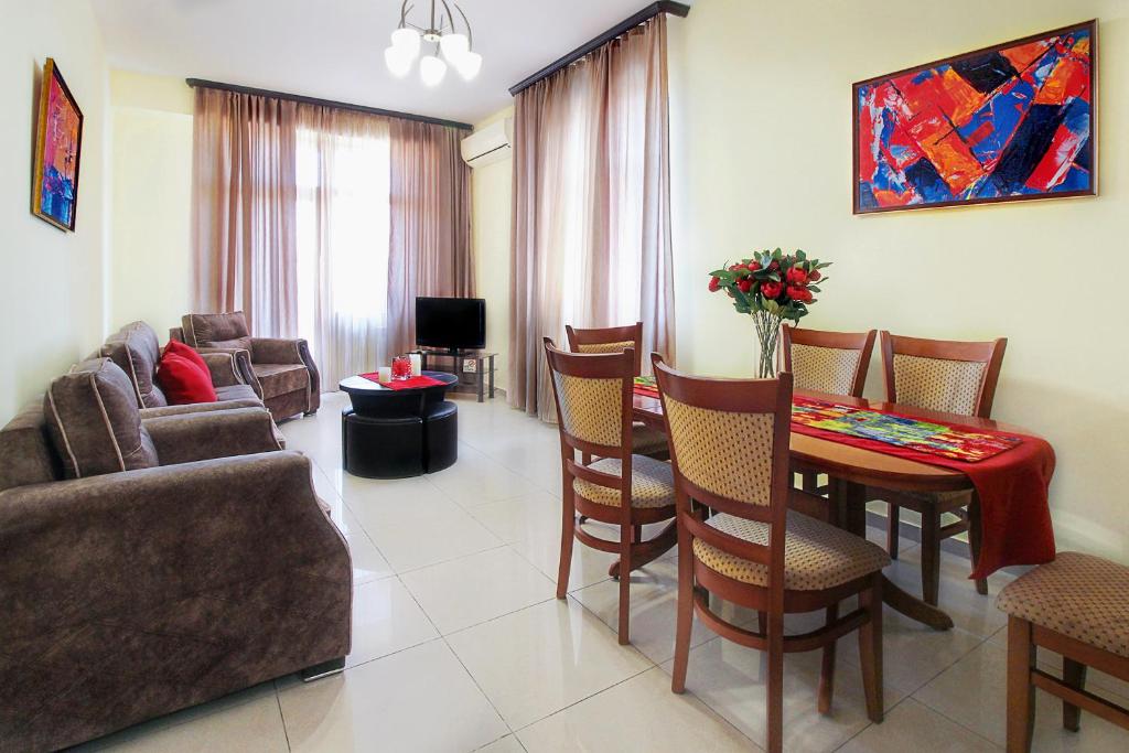 ein Wohnzimmer mit einem Sofa, einem Tisch und Stühlen in der Unterkunft 3 Bedroom Apartment in Homey Residence in Yerevan