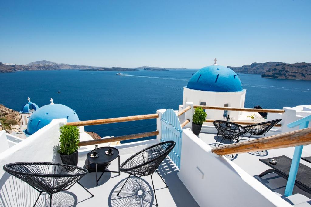 a patio area with chairs, tables and umbrellas at Luxus VIP Suites in Oia
