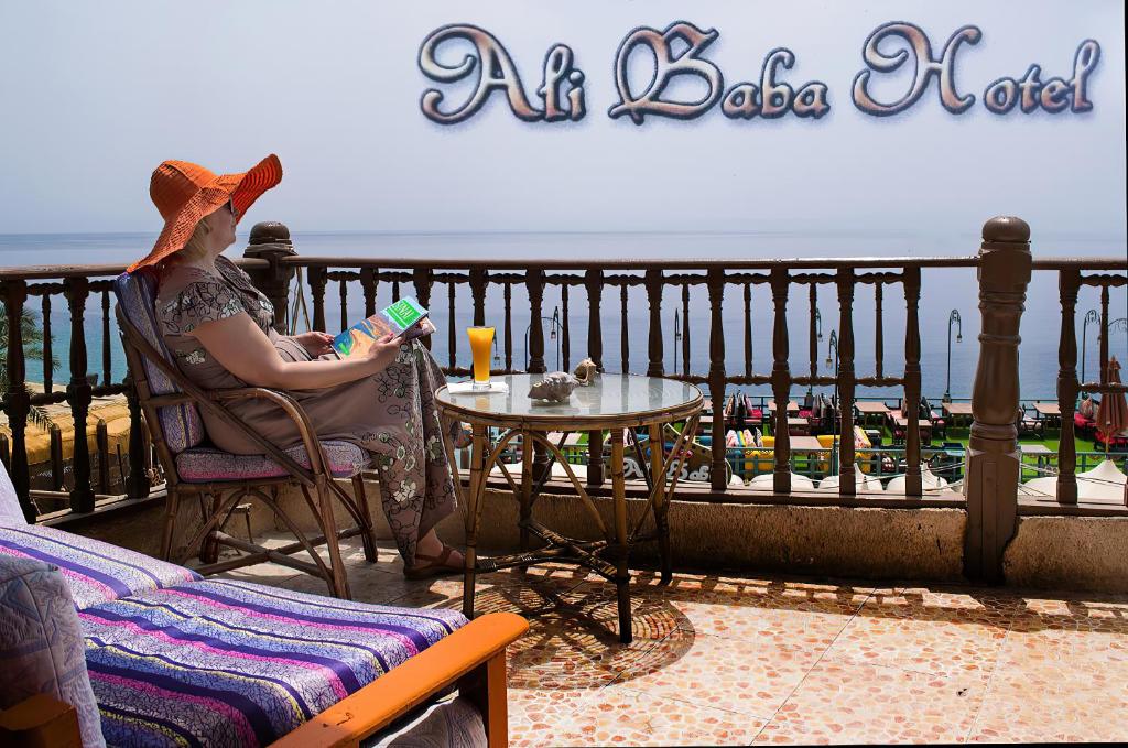 a woman sitting in a chair on a balcony at Ali Baba Hotel in Dahab