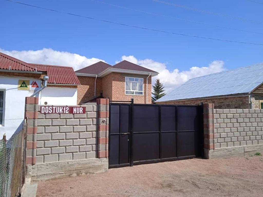 a black gate in front of a house at Guest House Nur in Kochkor