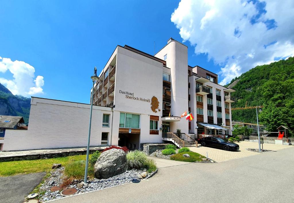 un edificio de hotel con una montaña en el fondo en Das Hotel Sherlock Holmes, en Meiringen