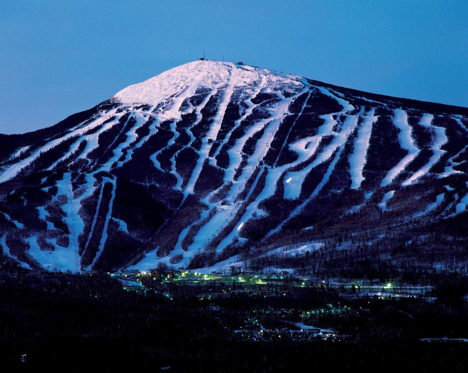 śnieżna góra z miastem przed nią w obiekcie Sugarloaf Mountain Hotel w mieście Carrabassett