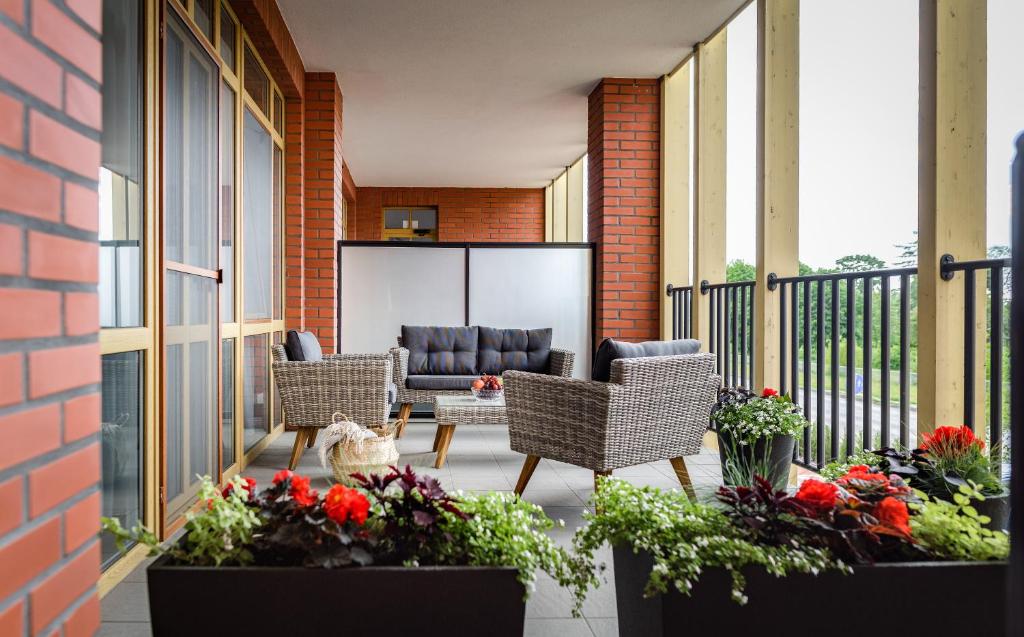 a patio with two chairs and a couch at Rusnės Perlo apartamentai in Rusnė