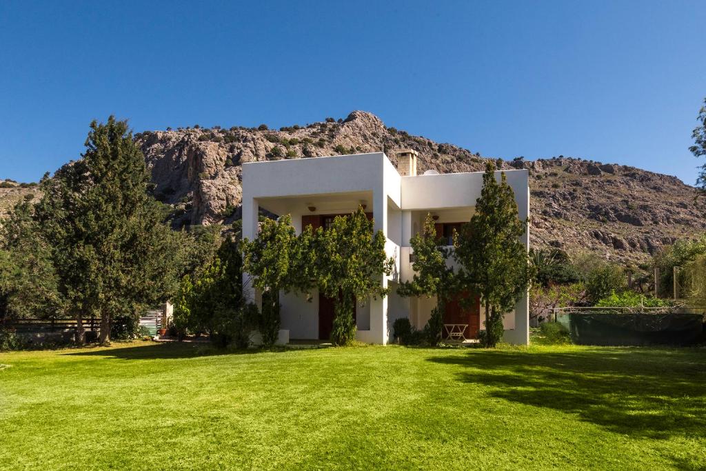 una casa bianca di fronte a una montagna di Villa Sole Mare a Pefki Rhodes