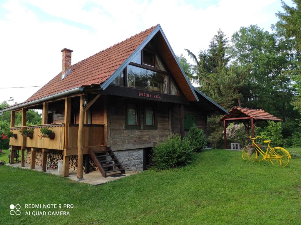 une maison avec une terrasse couverte et un vélo devant elle dans l'établissement Dorina hiža, à Karlovac
