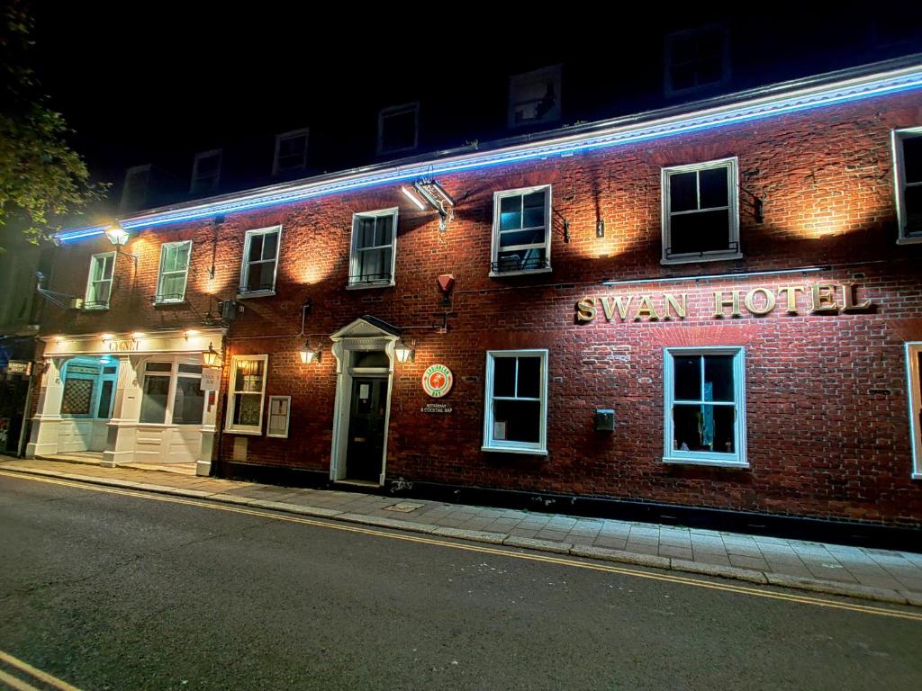 um edifício de tijolos com uma placa que lê hotel de metro em The Swan Hotel em Hythe