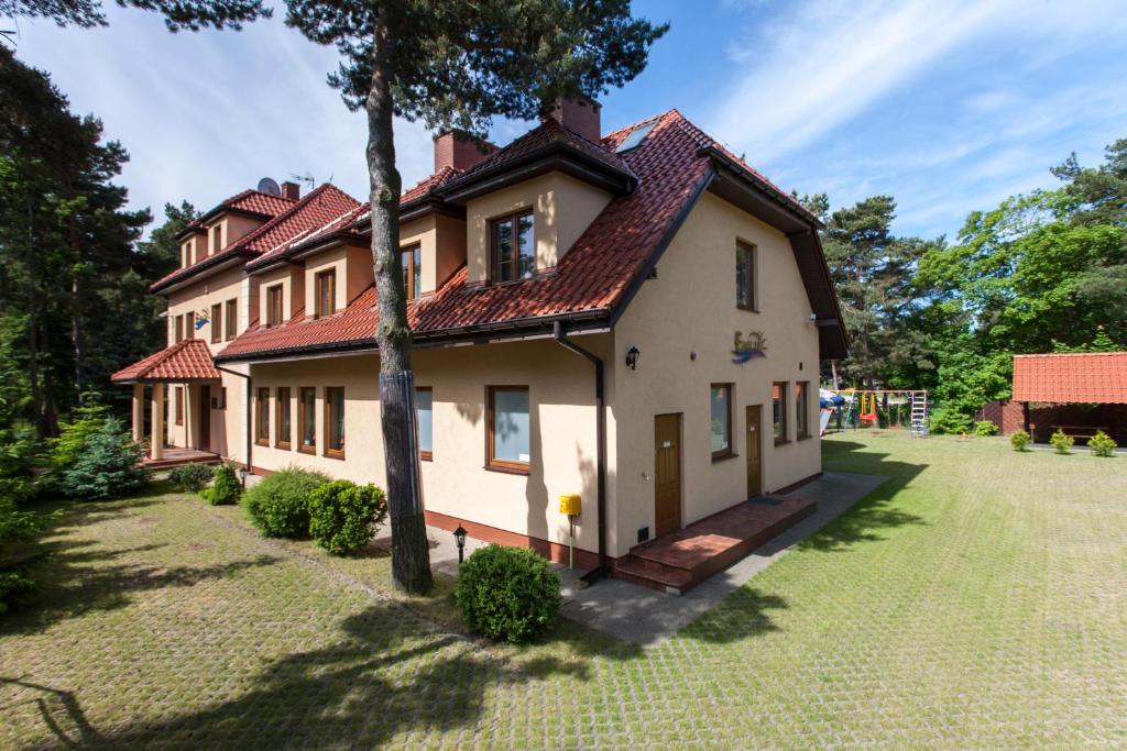 ein großes Haus mit rotem Dach in der Unterkunft Dom Gościnny Emilia in Pobierowo