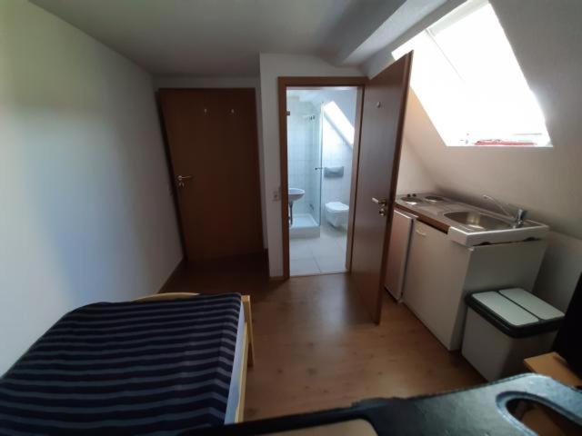 een kleine badkamer met een bed en een wastafel bij Biberach-Riss-Zimmer-frei, Einzel-Zimmer Bad Küche in Birkenhard