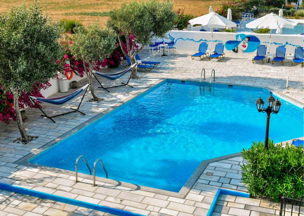a large swimming pool with chairs and a table at Dedalos Studios Naxos in Naxos Chora