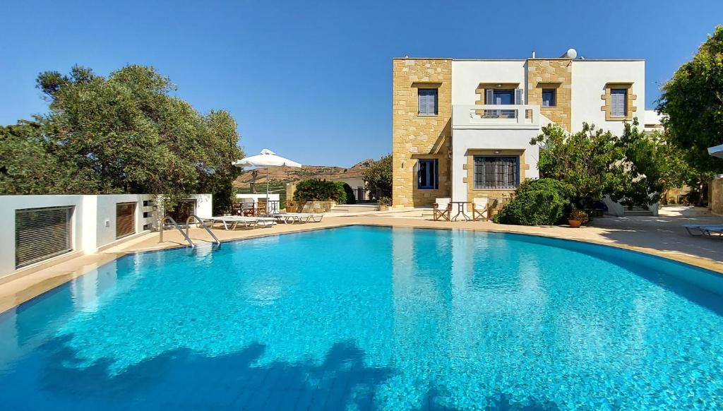 a large blue swimming pool in front of a house at Thealia in Karefilianá