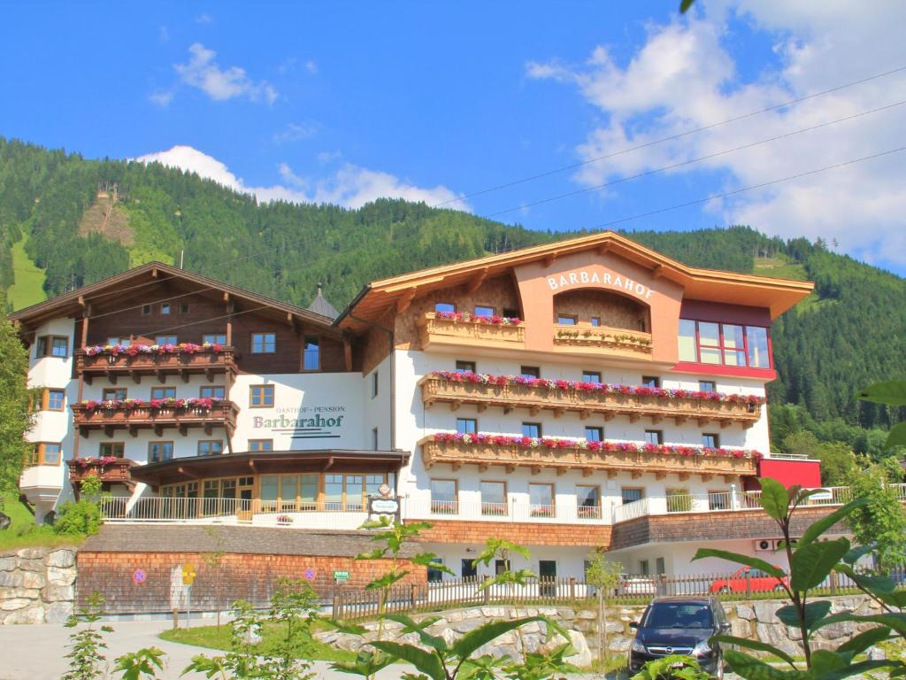 un hotel en una colina con montañas en el fondo en Barbarahof, en Werfenweng