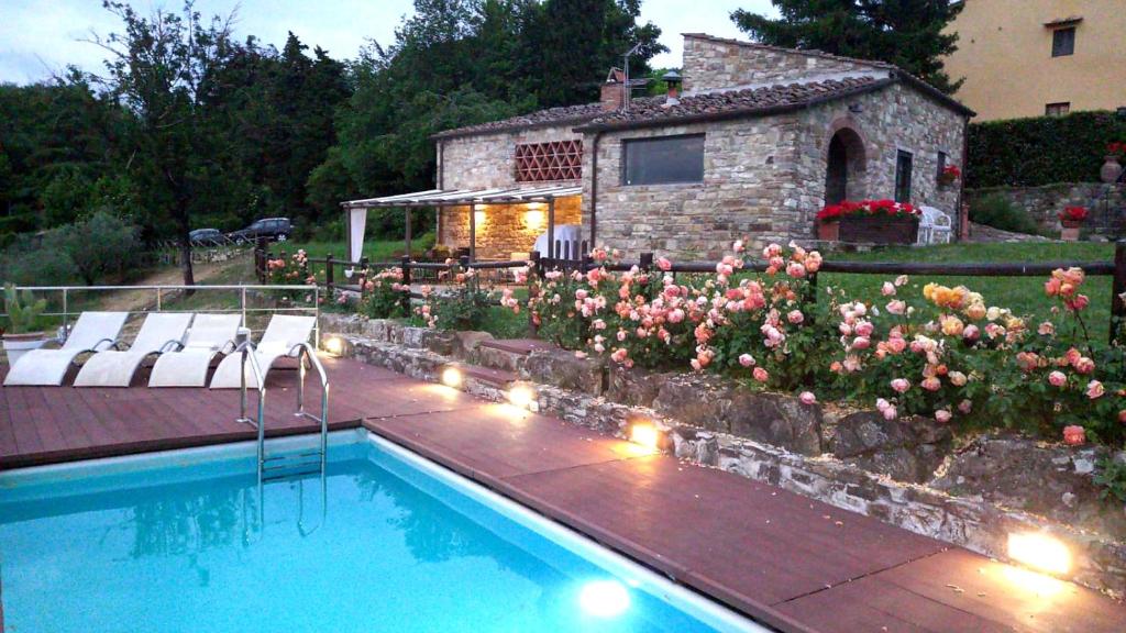 a swimming pool in front of a house with flowers at Poggio al Sole in Fiesole