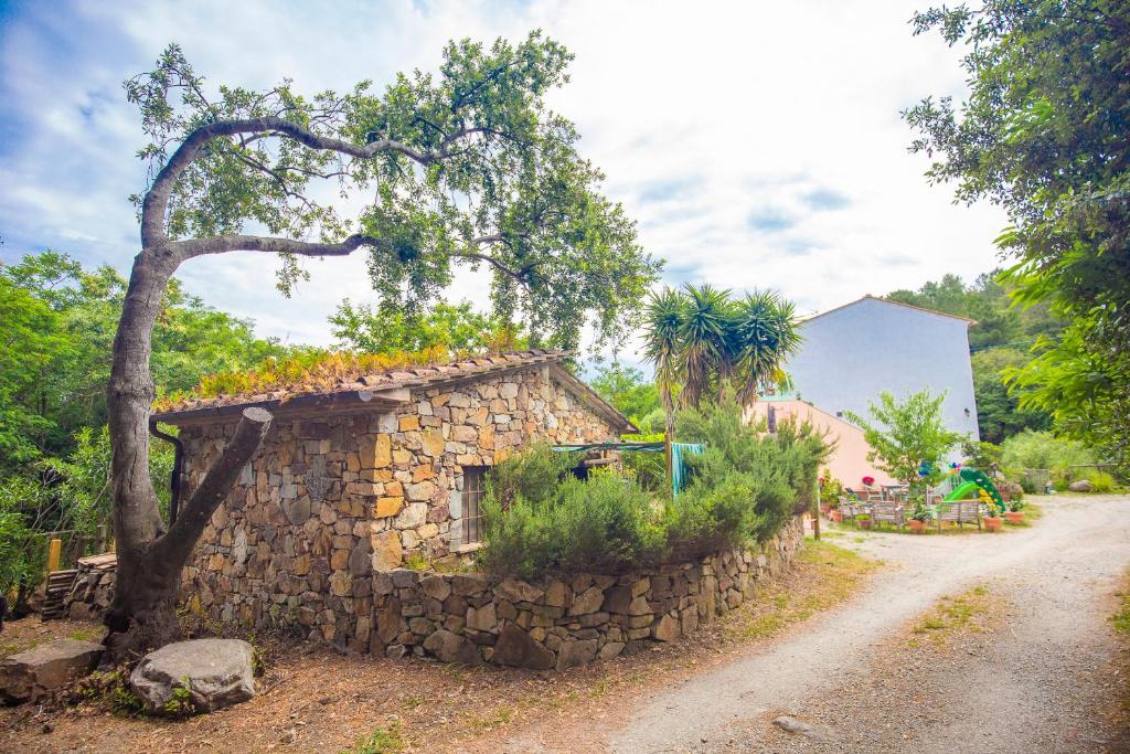 a small stone building next to a dirt road at Casa Emma by HelloElba in Marciana