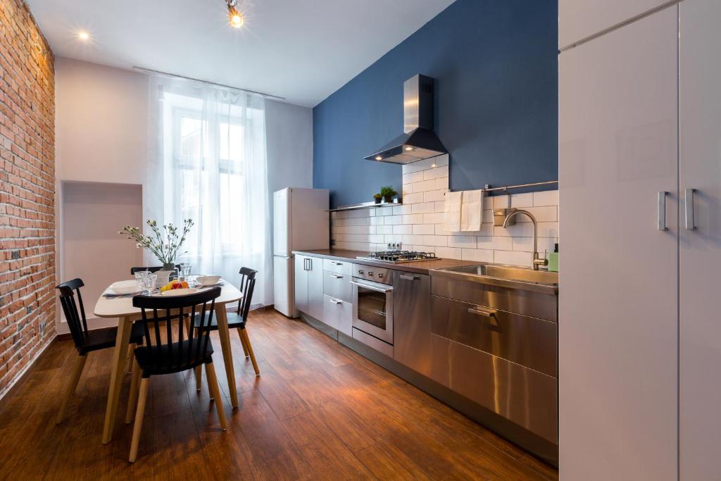 kuchnia ze stołem i kuchnia z niebieskimi ścianami w obiekcie FriendHouse Apartments w Krakowie